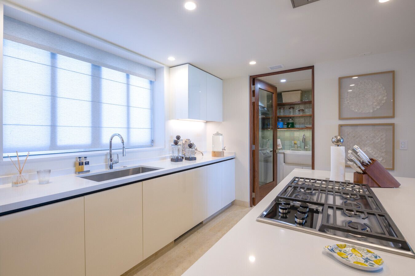 Una cocina moderna con un amplio ventanal, un lavamanos empotrado y una estufa a gas.
