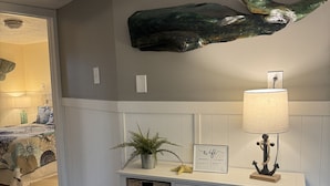 Une pièce avec une console blanche, une lampe fixée au mur, une sculpture de poisson décorative et un panneau indiquant « wifi ».