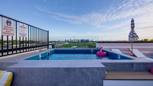A rooftop pool with clear pool rules and a view of the city skyline. - Ultra Heated Rooftop Pool! Arcade, Elevator, EV Charger, Sleeps 12, Full Home (Nashville)