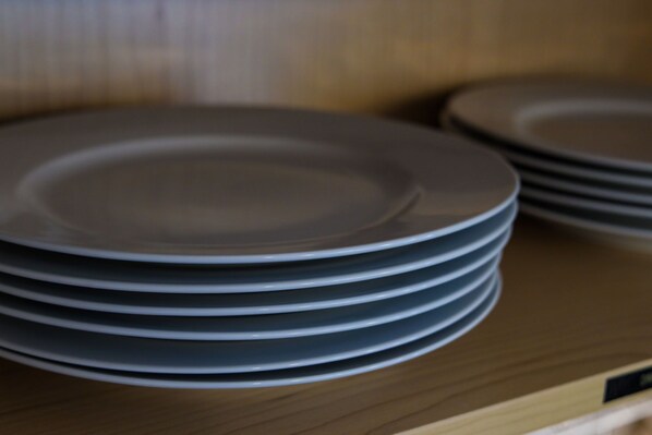 Une pile d’assiettes sur une étagère en bois.