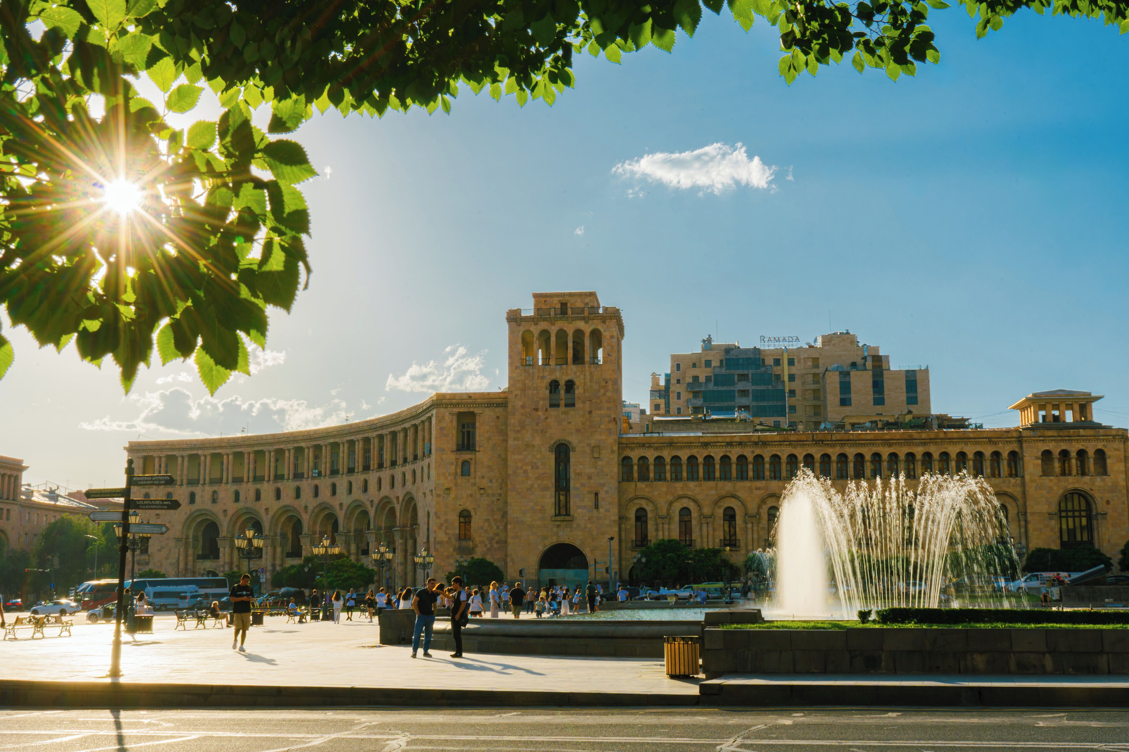 A large public square with a historic building featuring arched windows and a central tower.