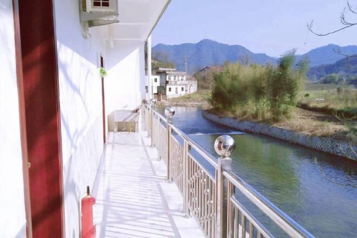 Een balkon met uitzicht op een rivier en bergen.