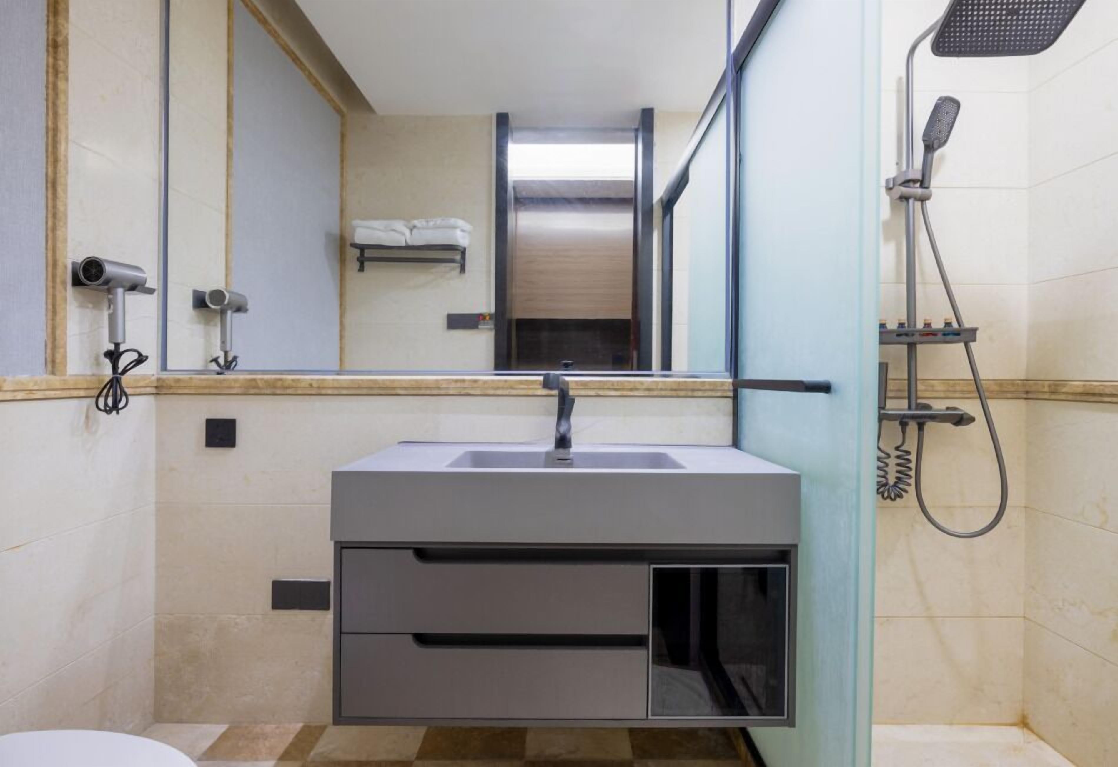 Ein modernes Badezimmer mit Waschbecken, Spiegel und Dusche.