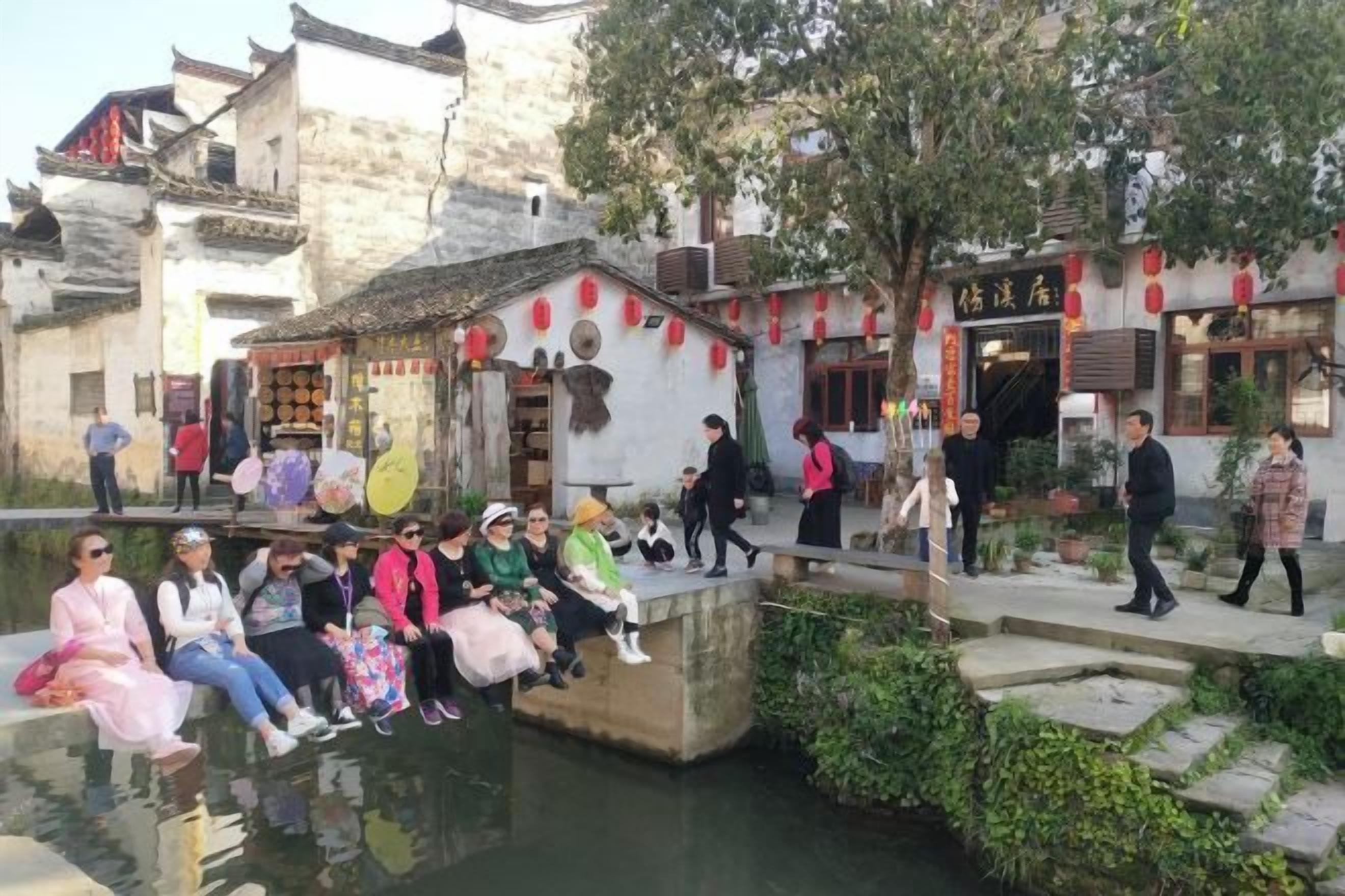 Un patio tradicional con escalones de piedra que conducen a una fuente, rodeado de edificios de arquitectura tradicional.