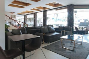 A modern living room with a sofa, chairs, a coffee table, and a staircase leading to an upper level. - RedDoorz Premium @ Nick Hotel Gerona Tarlac (Gerona)