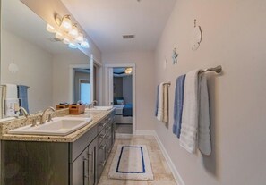 Casa de banho com duas pias, um espelho e um porta-toalhas.
