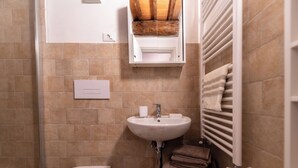 A bathroom with a white sink, a toilet, and a towel rack with towels. - Refined Home W/ Pool, Stunning View, and Relaxing (Volterra)