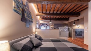 A bedroom with a checkered bedspread, a lamp, and artwork on the wall. - Refined Home W/ Pool, Stunning View, and Relaxing (Volterra)