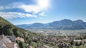 A valley with terraced vineyards, a town with traditional architecture, and mountains in the background. - Ferienwohnung in Kurtatsch an der Weinstrasse (Kurtatsch)