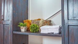 A wooden cabinet with shelves, a hanging basket, and a small green plant. - Raizes AXM (Circasia)