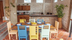 A dining area with a brick wall, wooden cabinets, and a tiled floor. - Raizes AXM (Circasia)