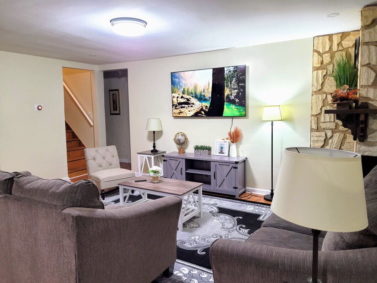 A living room with a sofa set, a coffee table, a TV, a lamp, and a fireplace.