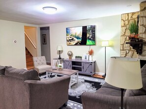 A living room with a sofa set, a coffee table, a TV, a lamp, and a fireplace. - Nice big house with parking, fenced yard (Buffalo)