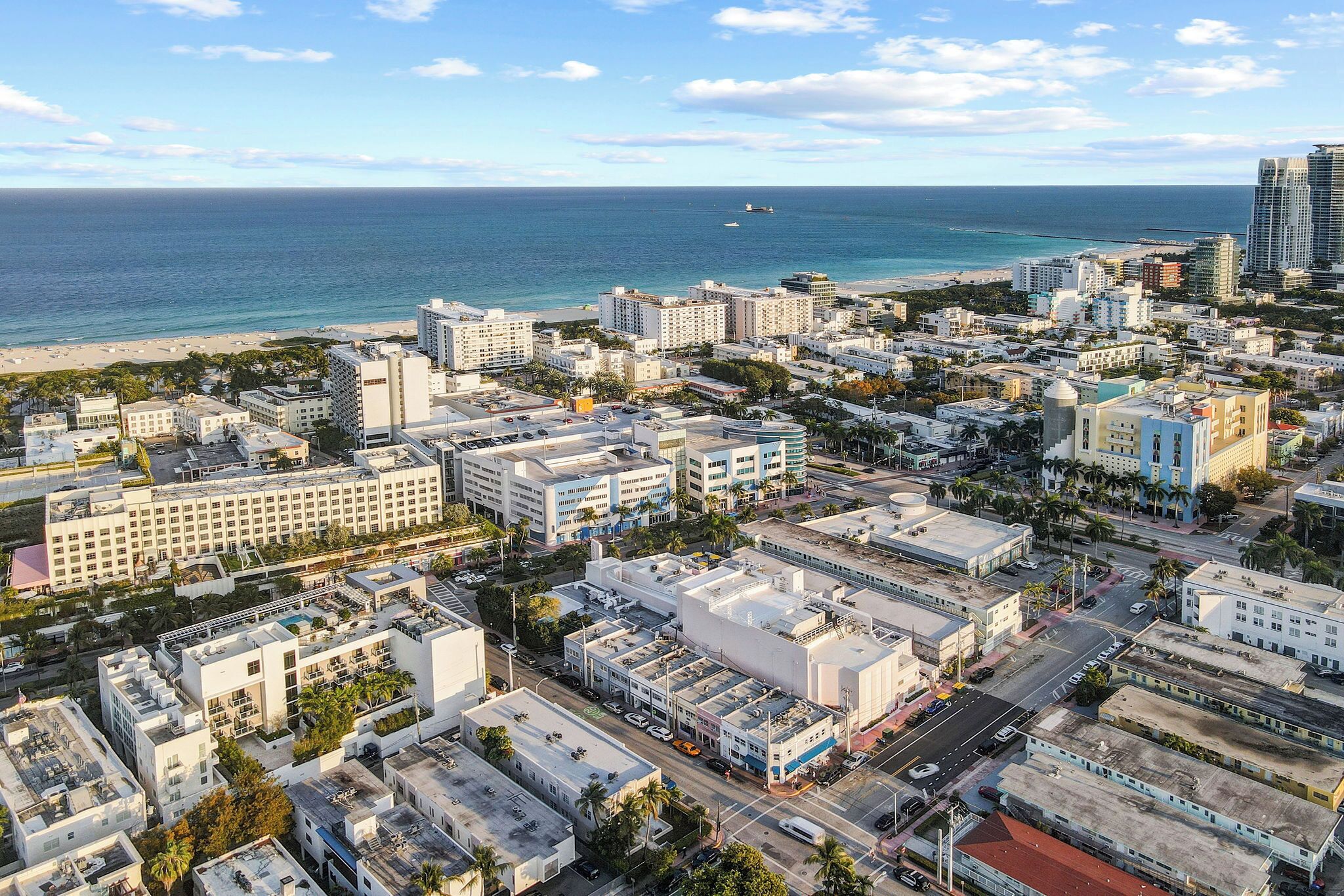 A coastal cityscape with a beachfront, high-rise buildings, and a mix of commercial and residential structures.