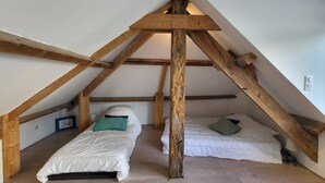 A small attic bedroom with two single beds, wooden beams, and a sloped ceiling. - Appartement Surplombant la mer et la Grand Plage, Centre des Sables, Tout à Pied (Les Sables-d'Olonne)