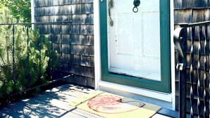 Une maison en bois avec une porte blanche et le numéro « 30 » peint sur le mur.