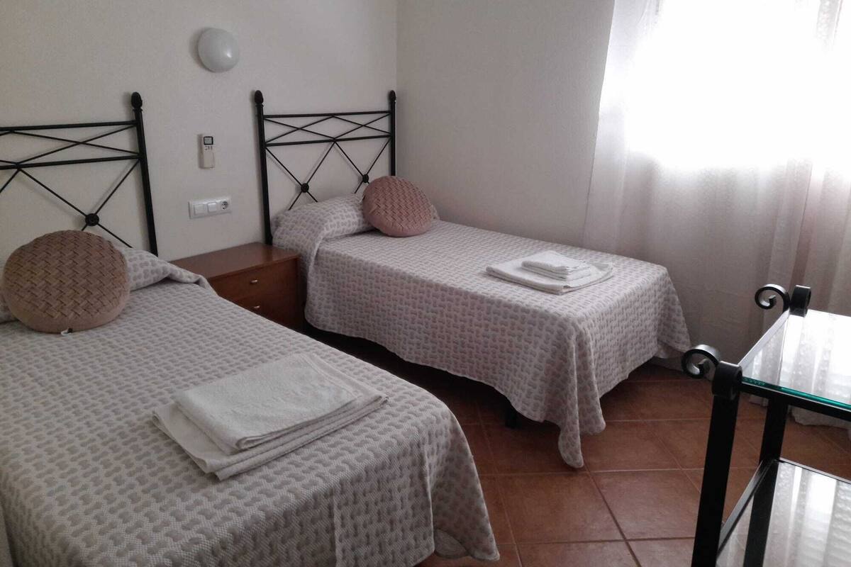 Une chambre à coucher avec deux lits, chacun doté d’une tête de lit, d’une table de chevet et d’une lampe.