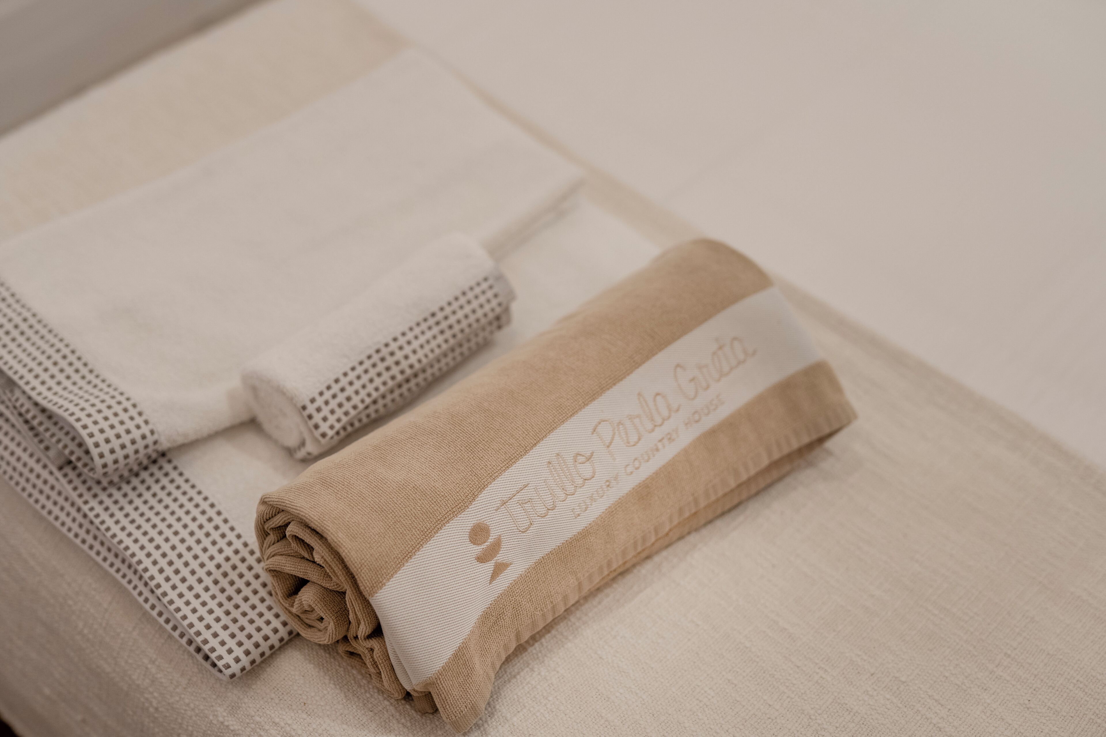 Toallas dobladas cuidadosamente con una etiqueta, sobre una superficie textil.
