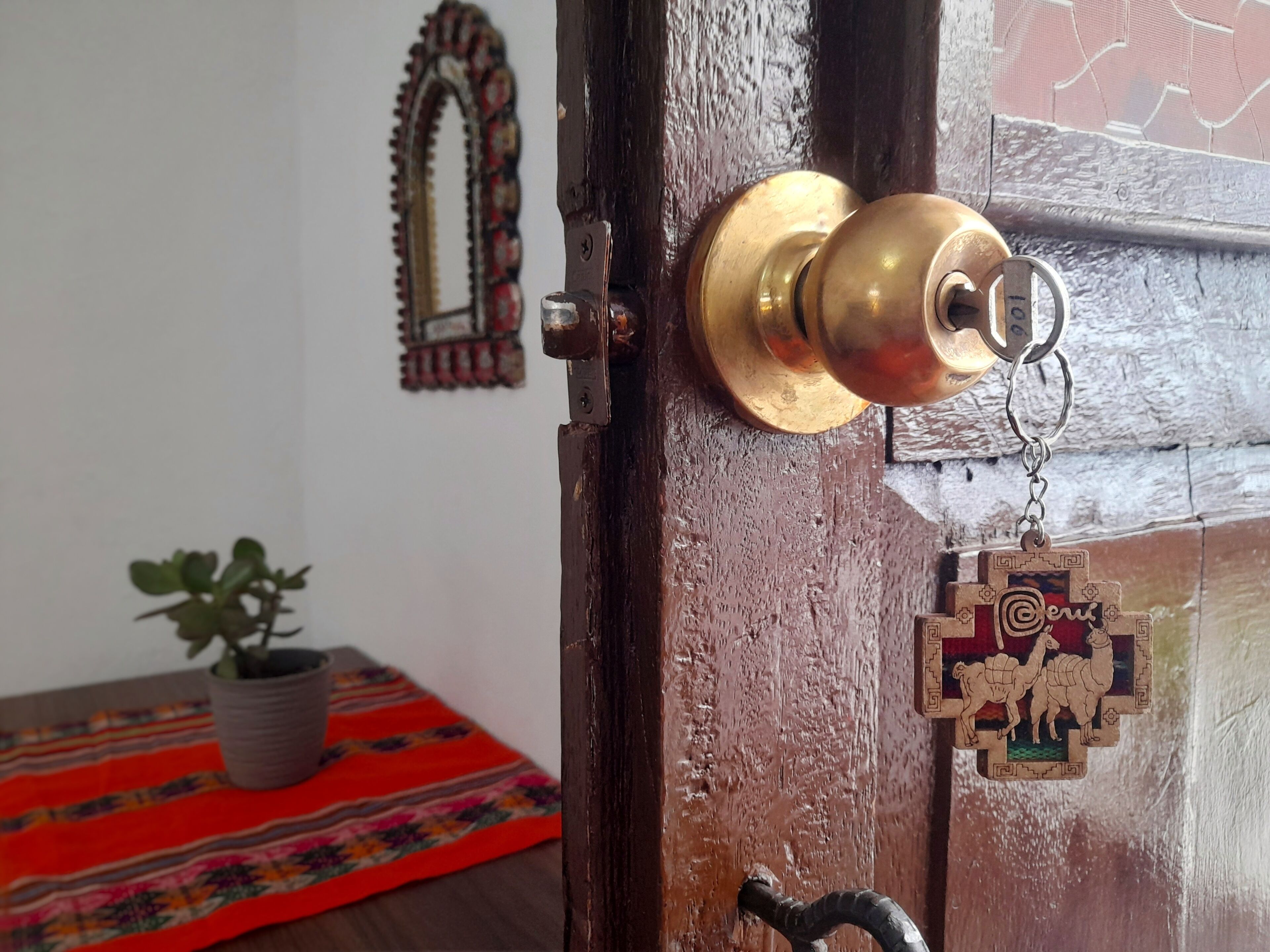 Una puerta de madera con un pomo de latón y un llavero decorativo.
