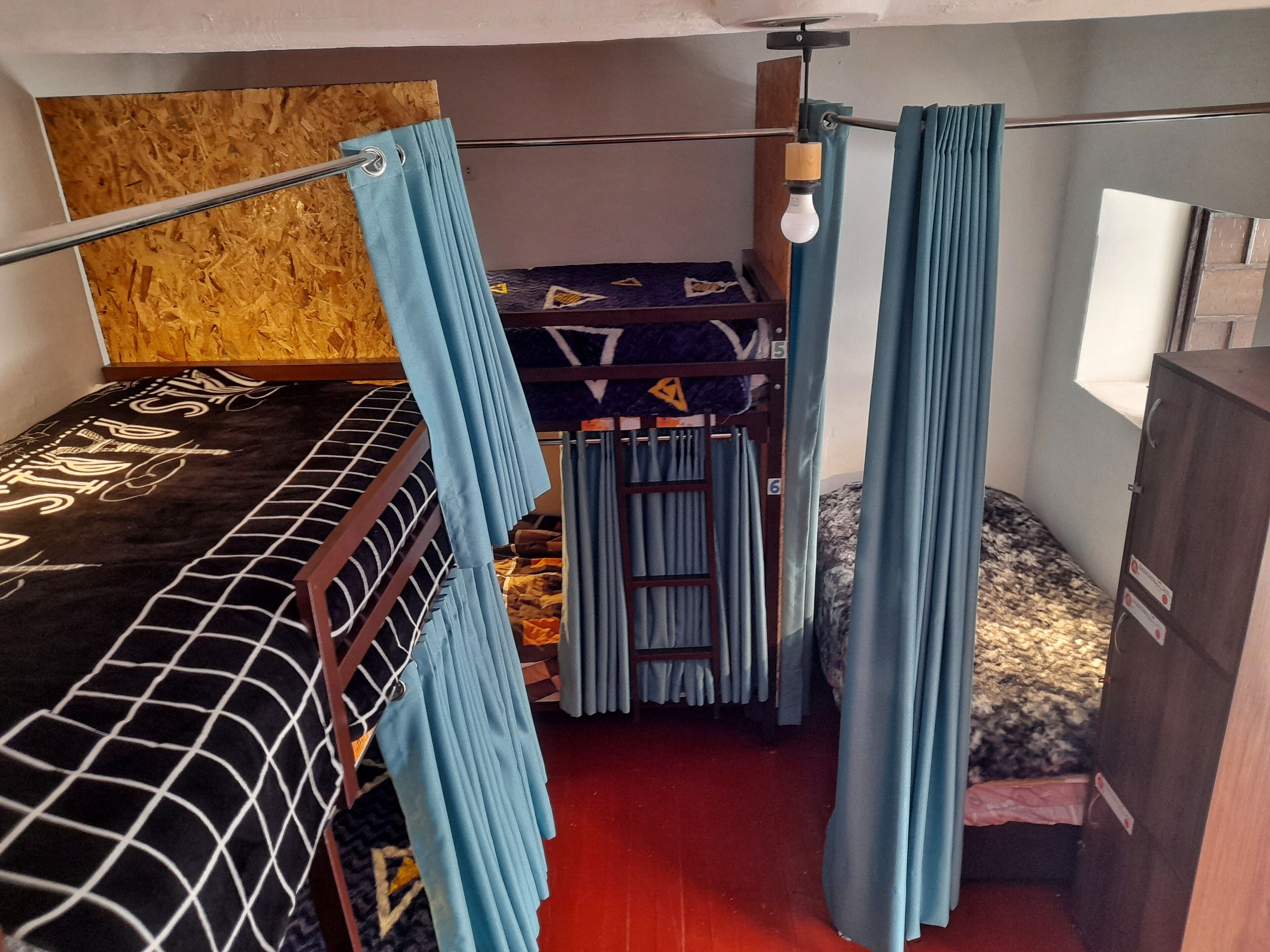 Una habitación pequeña con literas, un ventanal y un armario.