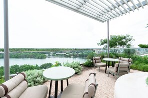 Relax in a tranquil outdoor space with a river view, under a shaded pergola.