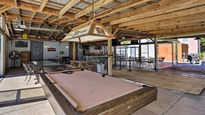 A pool table in a spacious indoor area with wooden beams, a bar, and multiple seating arrangements. - Golf Getaway w/ Pool Access in Myrtle Beach! (Myrtle Beach)