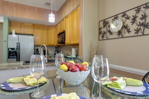 A dining table set with a fruit bowl, wine glasses, and napkins. - Golf Getaway w/ Pool Access in Myrtle Beach! (Myrtle Beach)