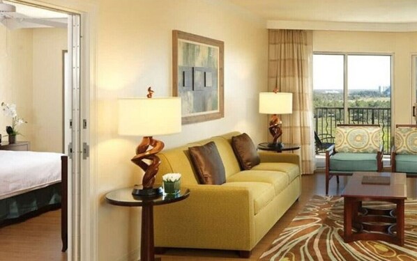 Relax in this stylish room with a sofa, artwork, and city views from the large window and balcony.