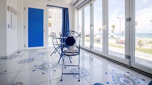 Une pièce dotée d’une grande fenêtre, d’une porte bleue et d’un sol à motifs.