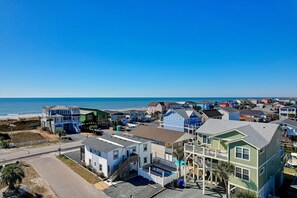 A coastal residential area with houses near the beach, featuring a mix of single and multi-story buildings, some with balconies and waterfront views. - Ocean View, Private Heated Pool, 6BR, 4BA, Sleeps 14. Fall Getaway Package. (Holden Beach)