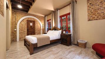 A bedroom with a wooden bed, a nightstand, a wicker basket, and a red bench.