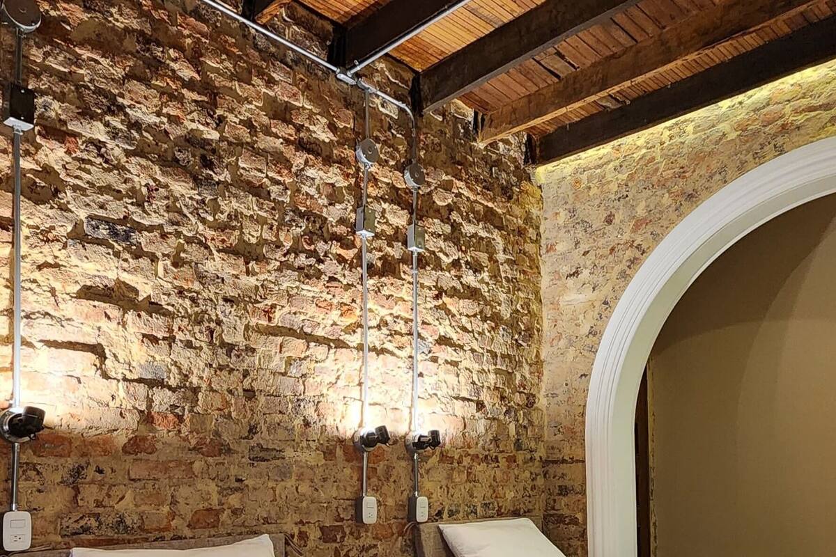 Ein Schlafzimmer mit zwei Betten, Holzbalken, Steinwänden und einem Steingewölbe.