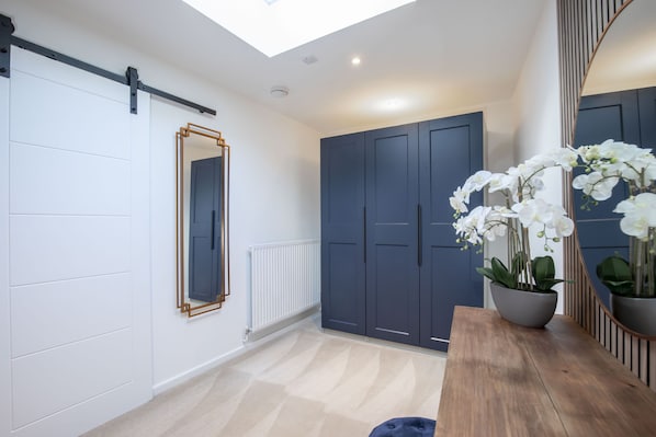 A modern interior with a sliding door, a mirror, a potted orchid, and a wooden table.