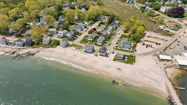 An aerial view of a coastal residential area with houses, a beach, and a marina. - Beach Cottage, private beach and pass (East Lyme)