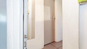 Un pasillo estrecho con una puerta cerrada al final.