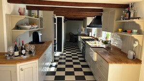 A kitchen with checkered flooring, wooden beams, and a central island with a sink and stove. - Beautiful 1700 century house in the heart of Viken. Pets Allowed! (Skåne län)