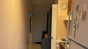 A narrow kitchen with a refrigerator, stove, and cabinets. - PRICE REDUCTION!  Polynesian Village pool side! Walking distance to Pier Park (Panama City Beach)
