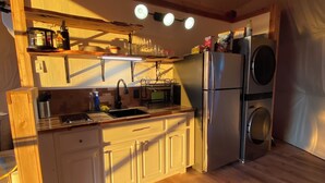 A compact kitchen with a sink, stove, and built-in washing machine. - Ventana Dome @ Rolling S Ranch (Bertram)