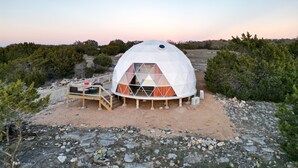 A geodesic dome structure with a wooden deck and a small staircase leading to an entrance. - Ventana Dome @ Rolling S Ranch (Bertram)