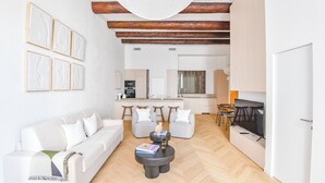 A modern living room with a sofa, coffee table, and artwork on the wall. - Le Marcel - Appart standing 3 ch avec clim (Marseille)
