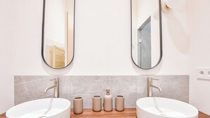 A bathroom with two white sinks, a wooden countertop, and a marble backsplash. - Le Marcel - Appart standing 3 ch avec clim (Marseille)