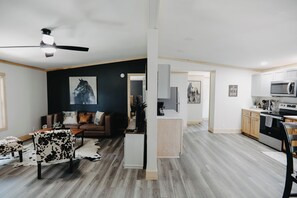 A modern living room with a dark accent wall, a sofa, a coffee table, and a cowhide rug. - Minutes to I-65! Clean Modern Home: Trail ride, Stargaze, Firepit &more (Elizabethtown)