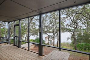 Une terrasse extérieure couverte avec vue sur un lac et des arbres.