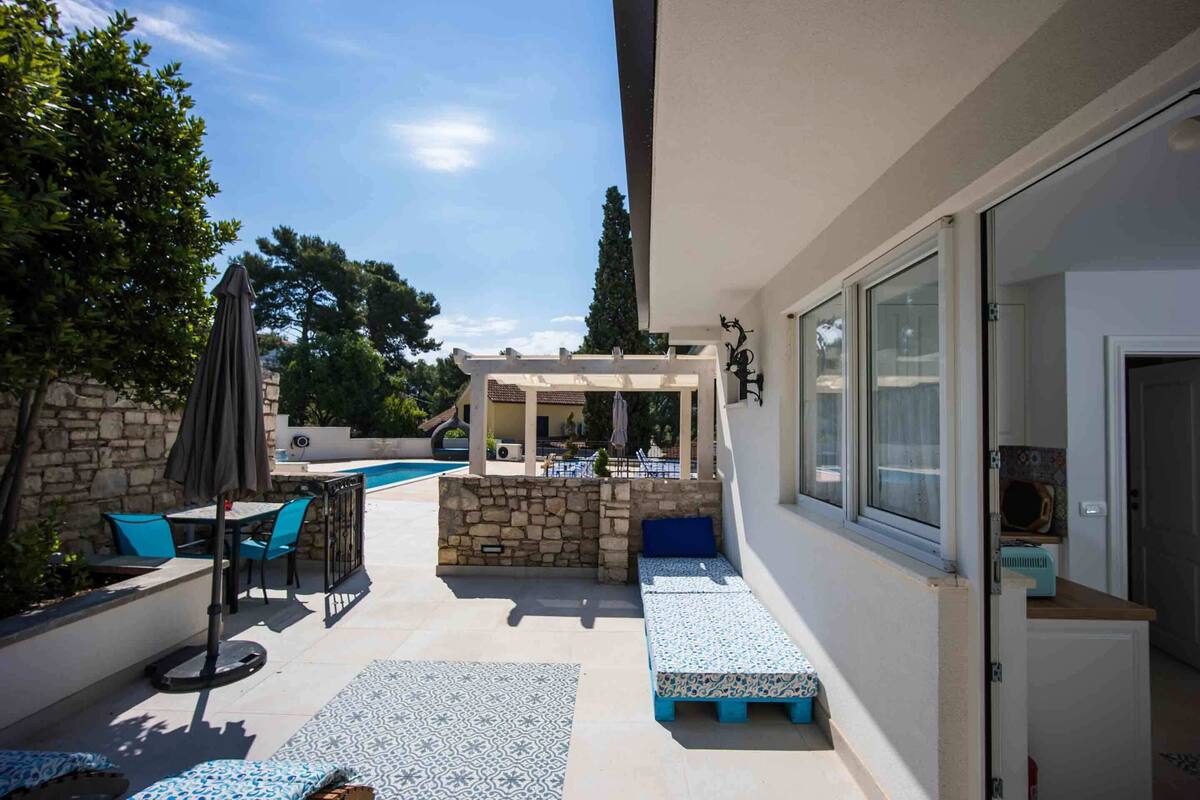 A patio area with a pool, outdoor seating, and a bar area.