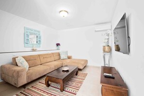 Deluxe-huoneisto, 1 keskisuuri parisänky, näköala uima-altaalle | Oleskelualue | Televisio