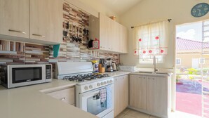 Une cuisine moderne équipée d’un four à micro-ondes, d’une cuisinière, d’un four et de divers ustensiles.