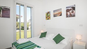 A hotel room with a bed, two bedside lamps, a window with a view of the outdoors, and three framed pictures on the wall. - Stunning home in Marza (Marza)