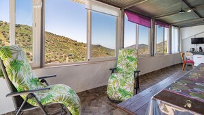 A room with two chairs, a table, and a view of a hilly landscape through large windows. - Lovely home in Canillas de Albaidas (Canillas de Albaidas)