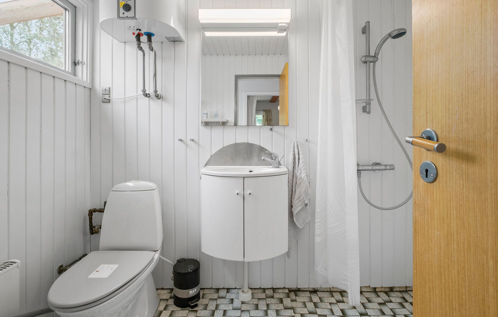 Une petite salle de bain comprenant des toilettes, un lavabo et une douche.