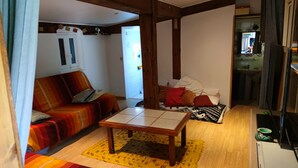 A cozy living room with a sofa, a coffee table, and a patterned rug. - Cabano for rent by the sea  (Hyères)